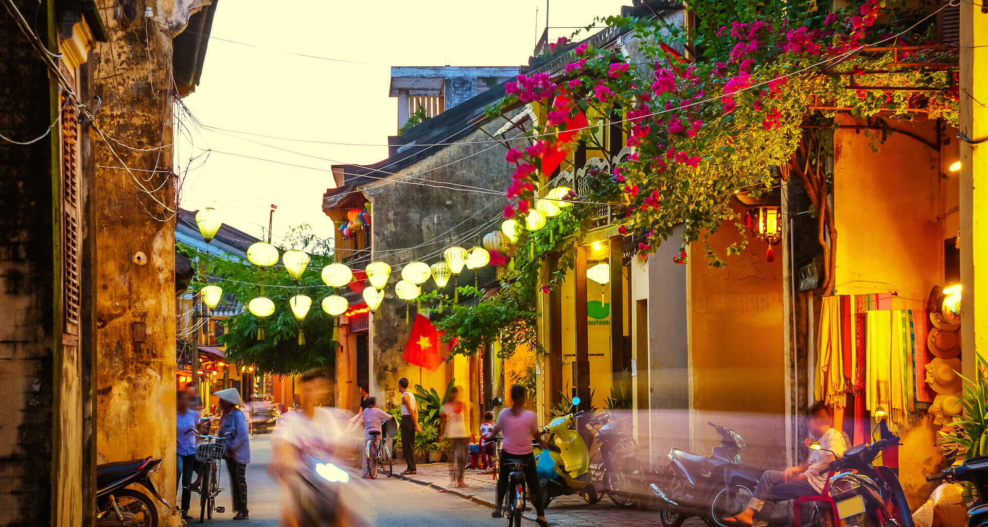 busy Street at duskSilk Lanterns in Hoi An an ancient city in Vietnampeople and scooter in motion blur.