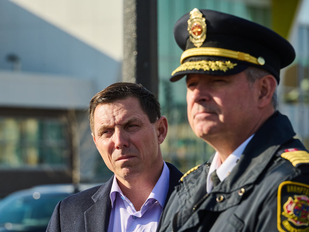 Man in suit standing by police chief in uniform