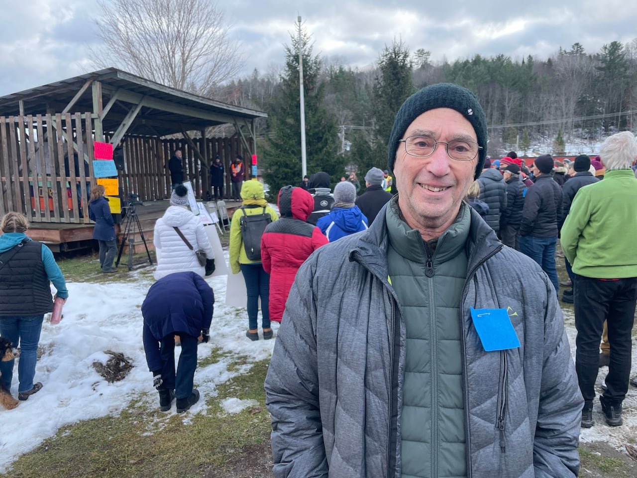 A smiling man standing in front of a crowd