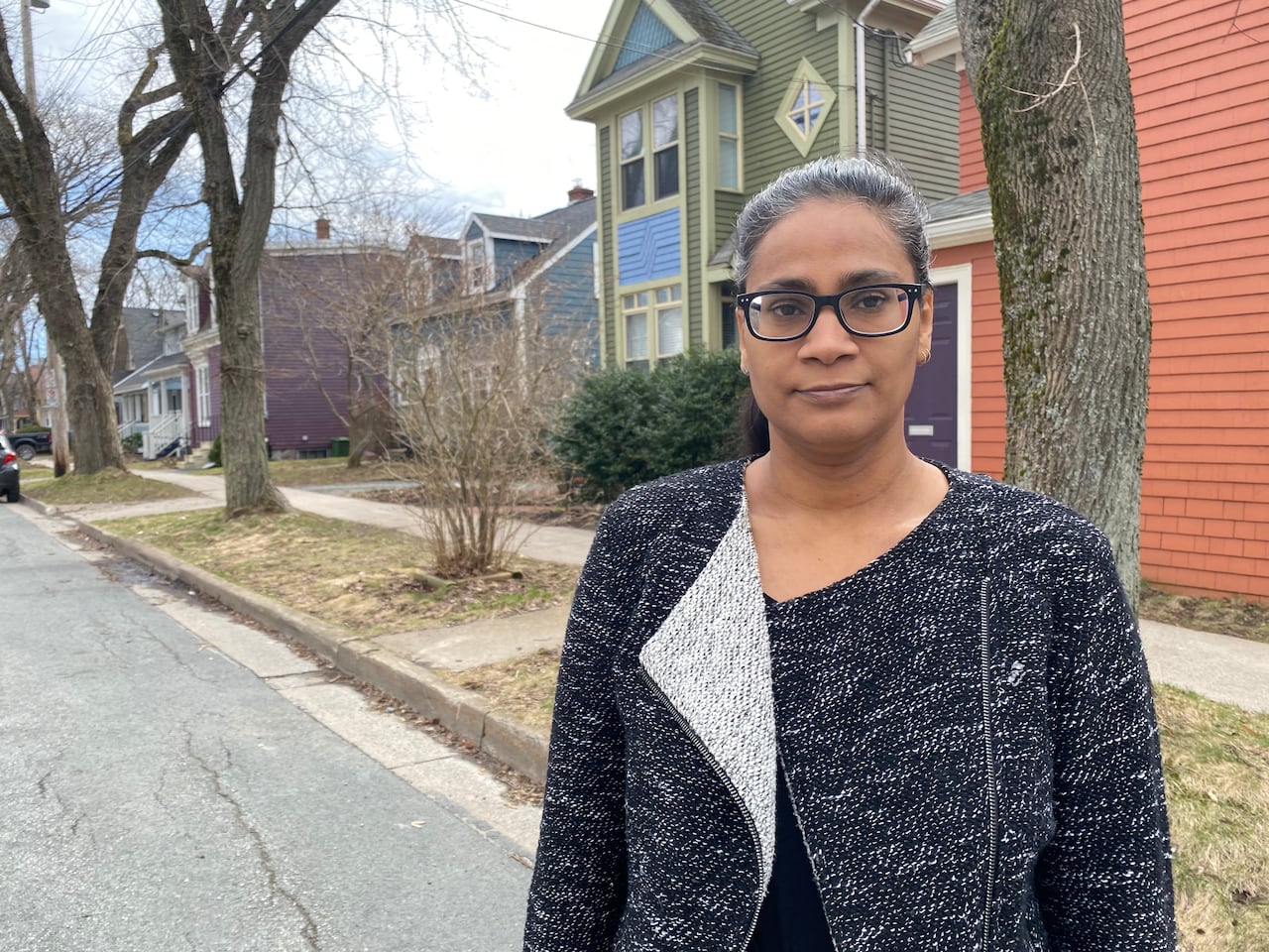 A woman stands on a street. The woman is Ren Thomas, an associate professor who specializes in urban planning at Dalhousie University.