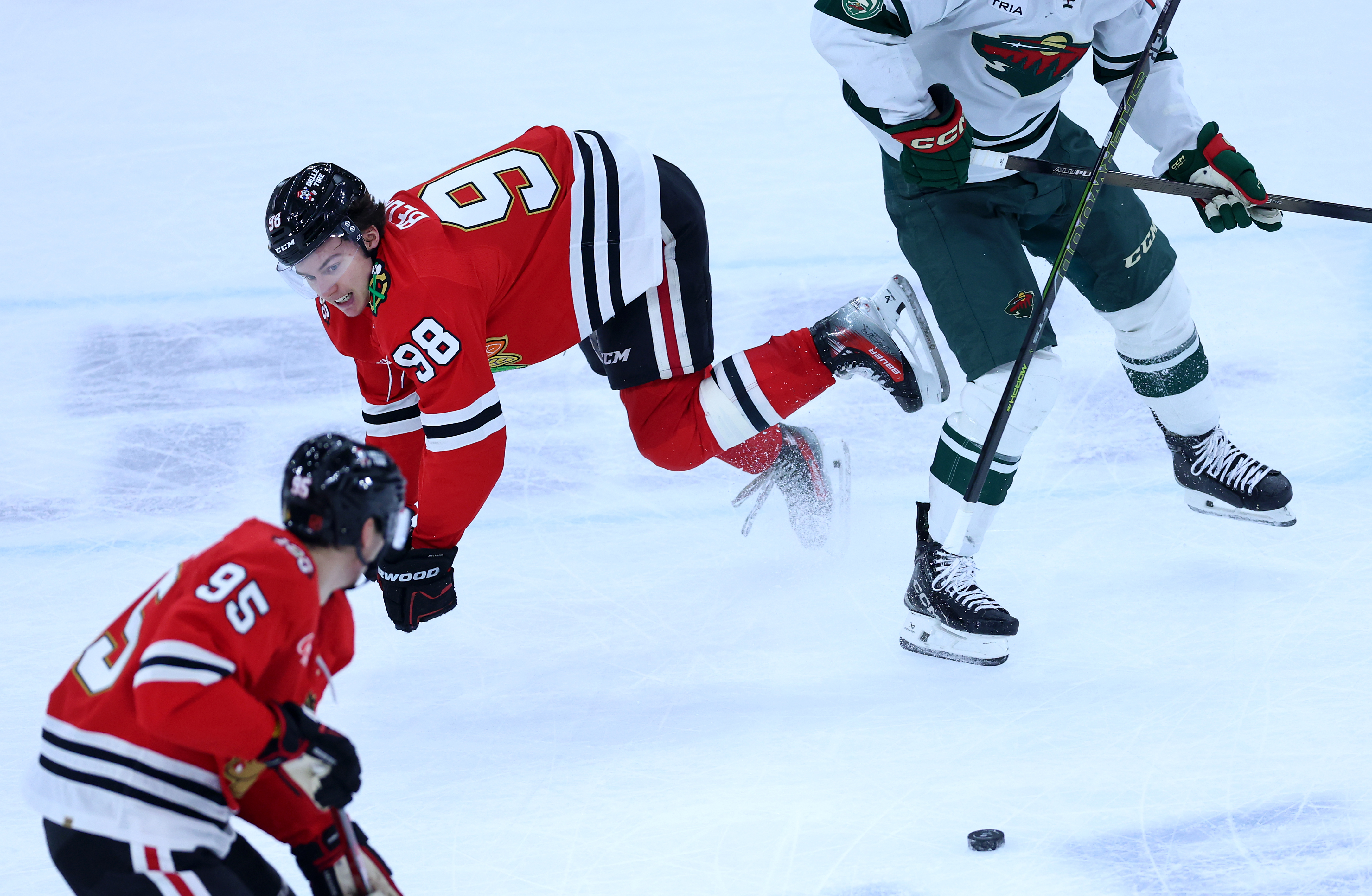 Chicago Blackhawks center Connor Bedard (98) is knocked to the ice in overtime of a game against the Minnesota Wild at the United Center in Chicago on Nov. 26, 2025. (Chris Sweda/Chicago Tribune)