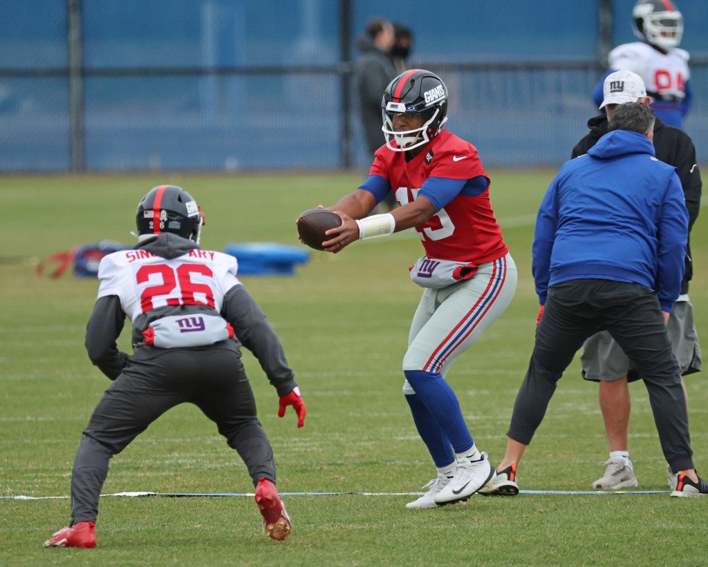 Giants quarterback Jameis Winston #19 hands the ball off to running back Devin Singletary #26, during practice at the New York Giants training facility in East Rutherford, New Jersey.