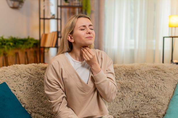 Woman touching her throat