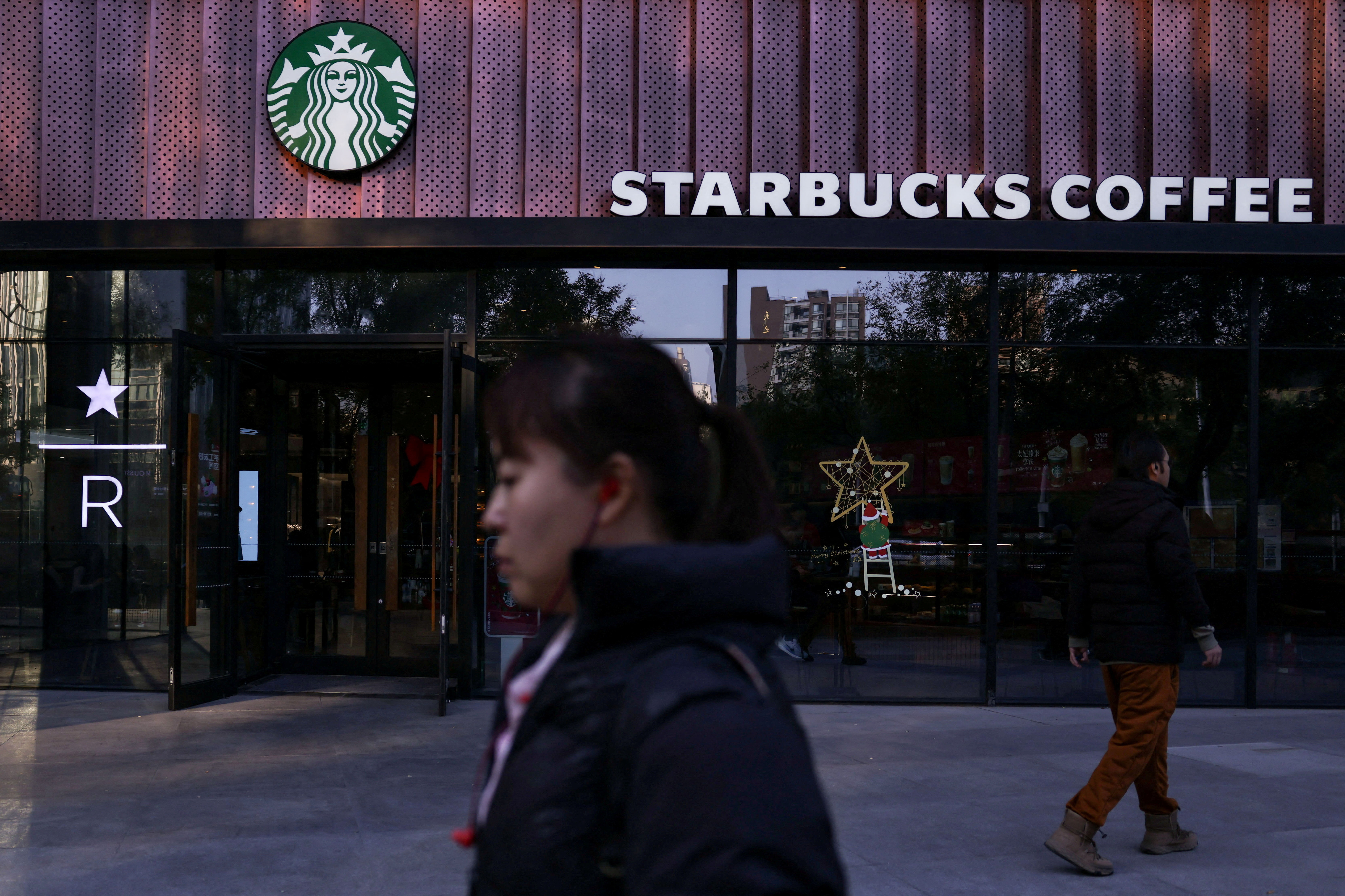People walk past a Starbucks coffee shop in Beijing, China, November 4, 2025. 
