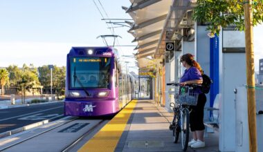 A woman waits for the arriving train at the Baseline/Central Avenue light rail station in Phoenix.