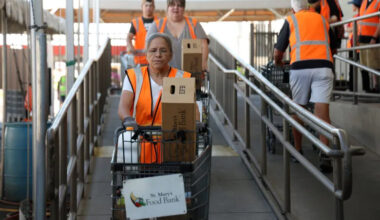 Volunteers Angie Velasquez, front, Jacquie Serr and Andrew Cyber push carts filled with food at St. Mary’s Food Bank in Phoenix on Thursday, Oct. 30, 2025.