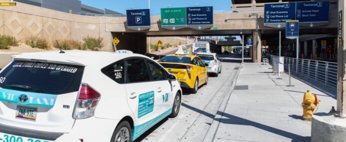 Taxi cabs wait at the curb at Phoenix Sky Harbor International Airport.