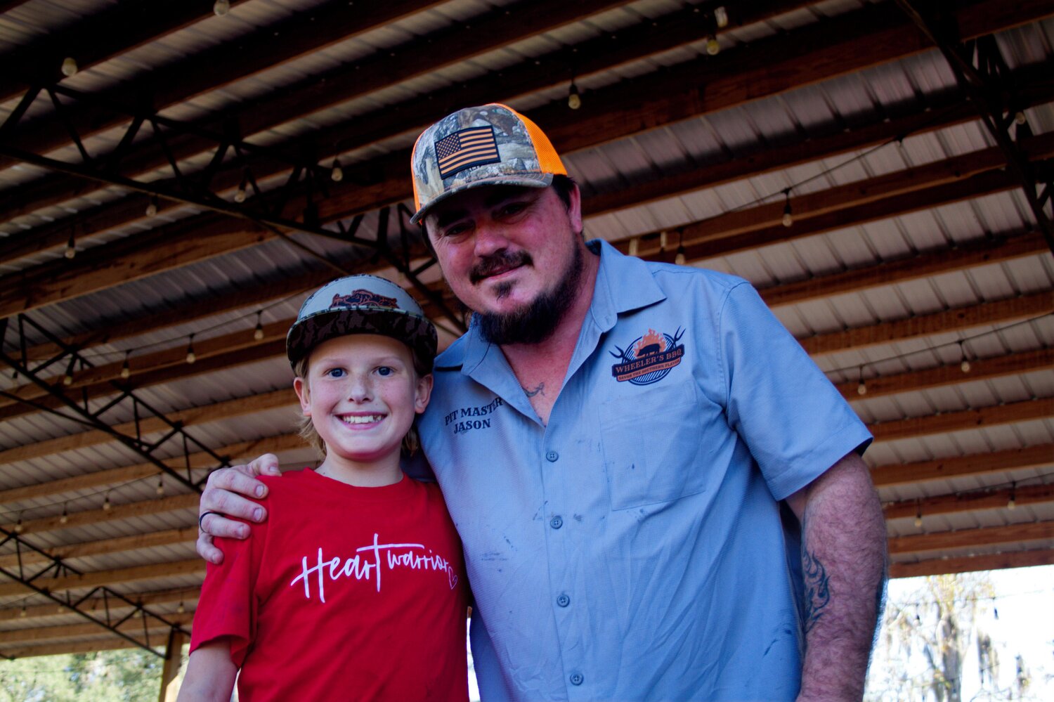 Bryce Bagley, left, and organizer Jason Wheeler take a moment to congratulate each other after their BBQ Ribs and Wings Cookoff raised $11,358 for the Healing Hearts Project.