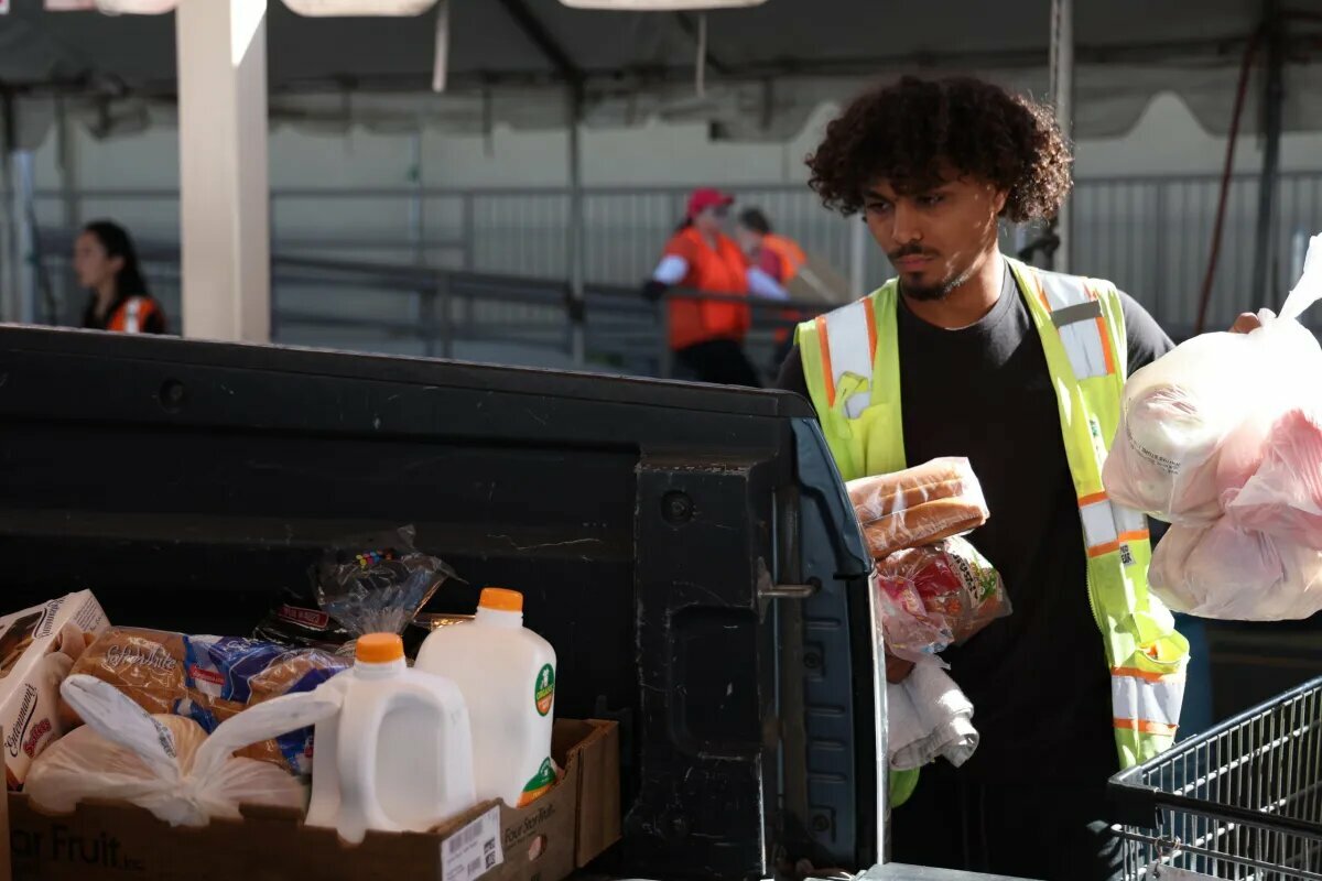 Volunteer Tristan Pall packs food boxes in a truck bed at St. Mary’s Food Bank in Phoenix on Oct. 30, 2025.
