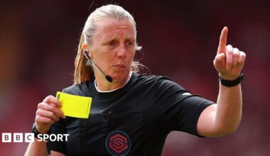 Referee Lisa Benn holding a yellow card