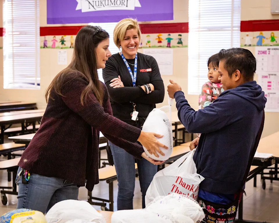 At San Jose Elementary School in 2024, a family gets a turkey and all the Thanksgiving fixings from NexGen Roofing staffers. The company holds an annual Thanksgiving meal giveaway, with turkeys donated by the Russell Rowland Inc. turkey drive.