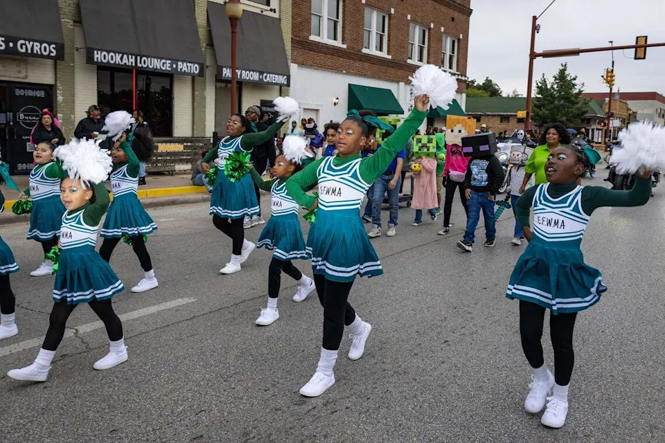 Cheerleaders from East Fort Worth Montessori Academy march down Main Street for the Día De Los Muertos Parade in Northside Fort Worth on Saturday, Nov. 1, 2025.
