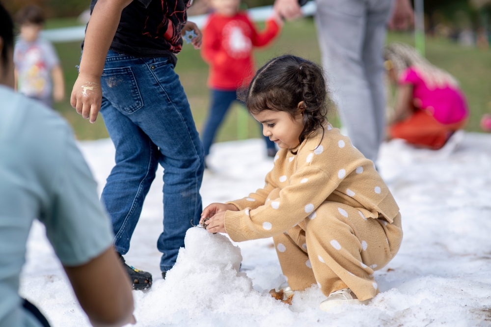 a young girl playing in snow