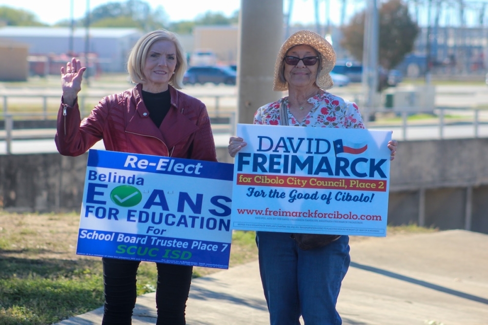 Two women hold up campaign signs on Election Day in the San Antonio, Texas area.