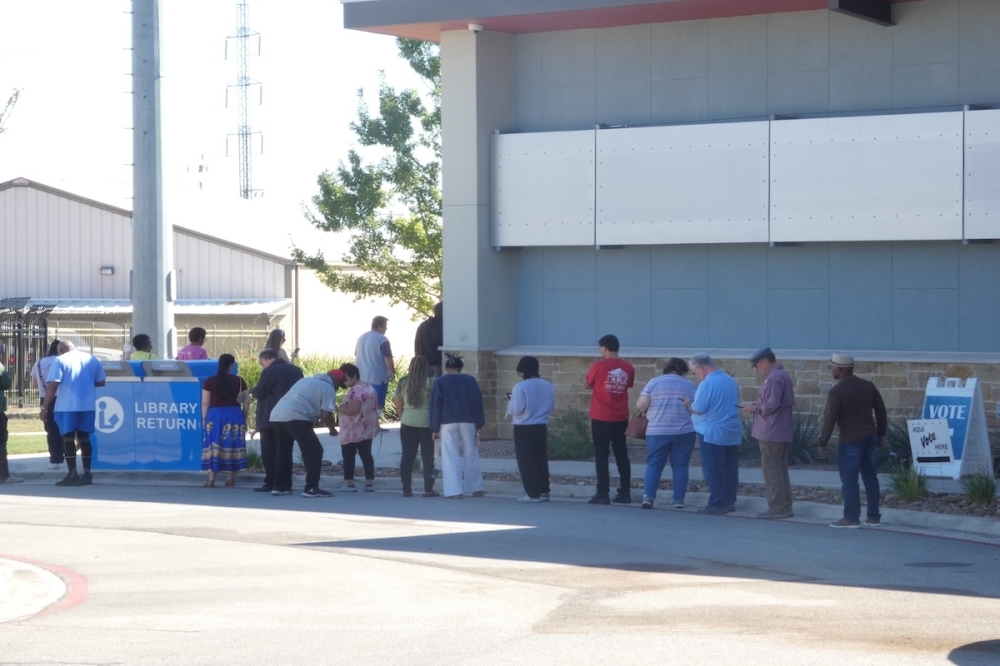 People are lining up to vote on Election Day outside of a library in Universal City, Texas.