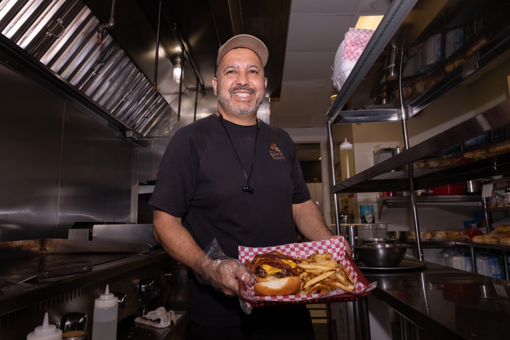 Tony Marron, owner of Uncle Tony's, posing with a fresh burger