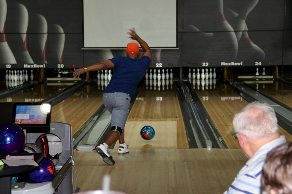 a person rolls a bowling ball down a bowling lane