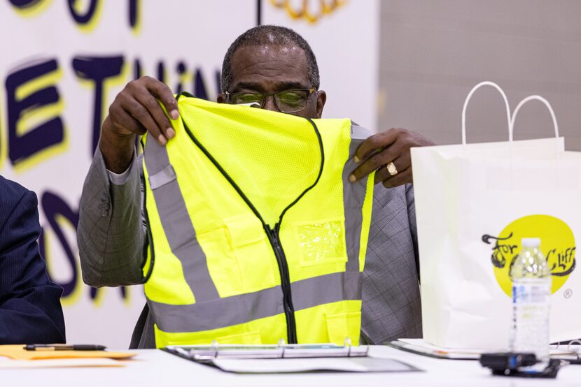 Texas Sen. Royce West holds up a crossing guard vest given to him by Taylor Toynes, with For...