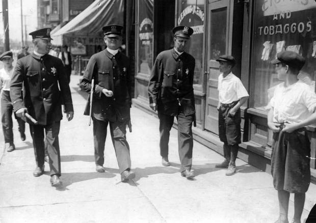 Police armed with rifles walk their beat during the Chicago...