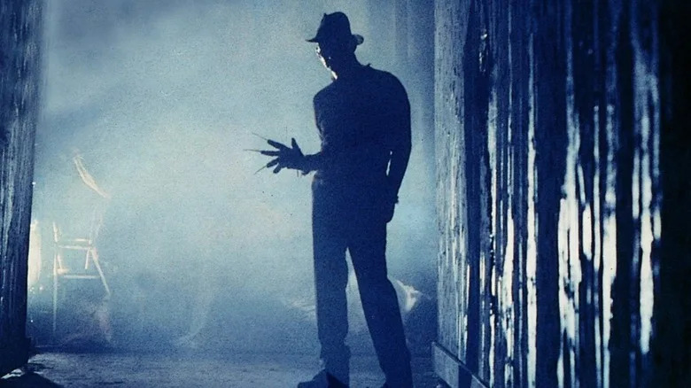 Freddy Krueger standing at end of dark hallway in "A Nightmare on Elm Street"