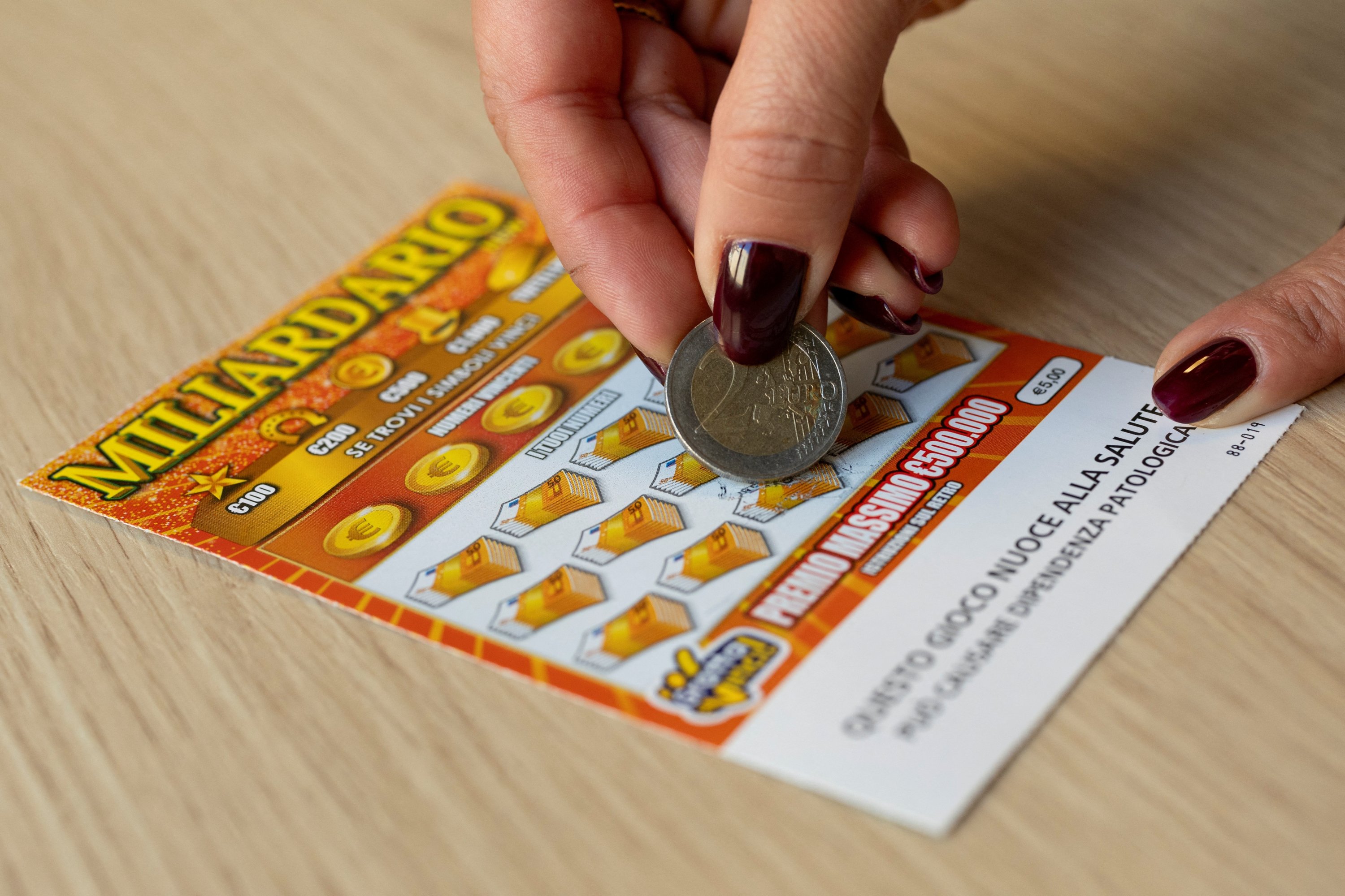 A woman plays a scratchcard in this illustration taken in Rome, Italy, Oct. 28, 2025. (Reuters Photo)