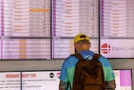 A man checks a flight status board at Dallas Love Field, Friday, Sept. 19, 2025, in Dallas.
