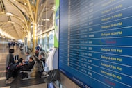 The departures display board shows multiple flights delayed at Ronald Reagan Washington...