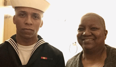 USD student veteran Jack Atkinson poses with his mother for a photo while wearing his U.S. Navy uniform.