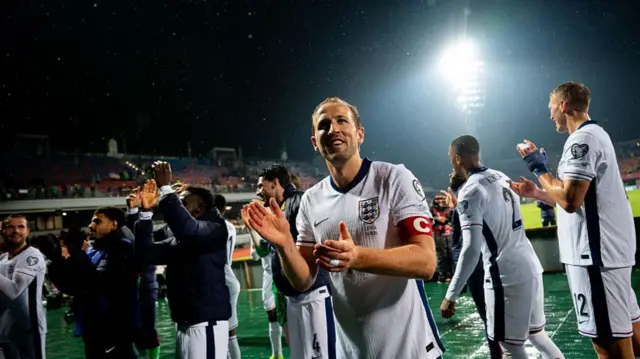 England captain Harry Kane and team-mates celebrate after securing qualification for the 2026 World Cup with a win in Latvia