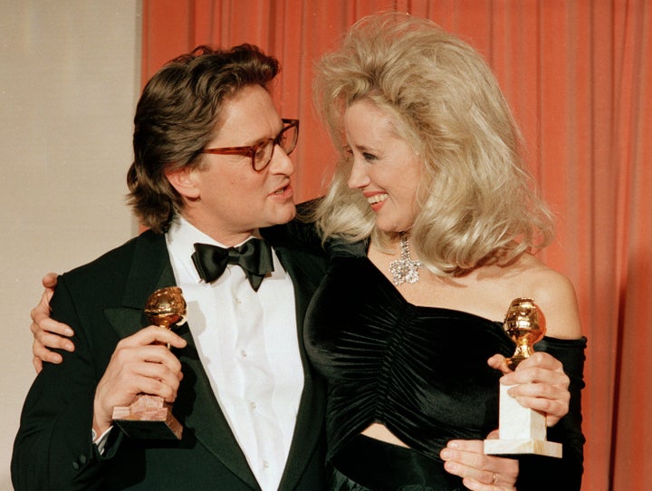 Michael Douglas, left, and Sally Kirkland appear with their awards for best actor for "Wall Street" and best actress for "Anna," at the 45th Annual Golden Globe Awards in Beverly Hills, Calif., on Jan. 24, 1988. (AP Photo/Reed Saxon, File)