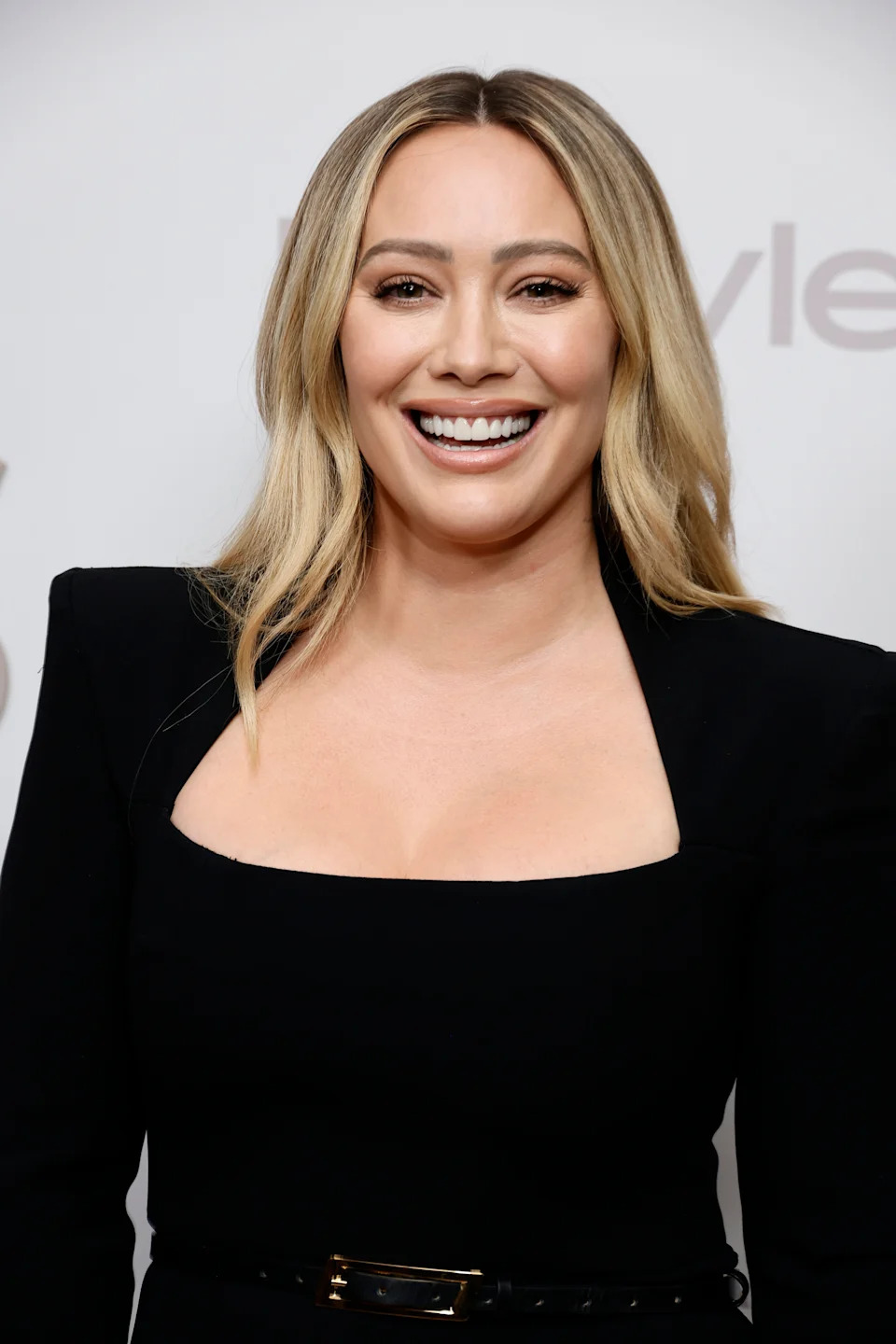 Hilary Duff in a chic black dress with structured shoulders at a formal event