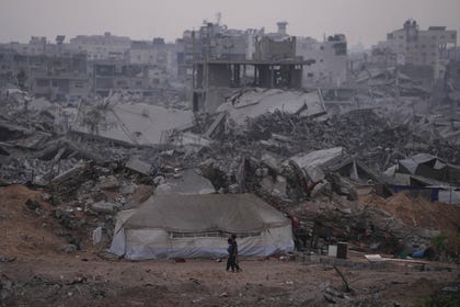 Palestinians walk through the destruction caused by the Israeli air and ground offensive in Sheikh Radwan neighborhood in Gaza City, Monday, Nov. 10, 2025.