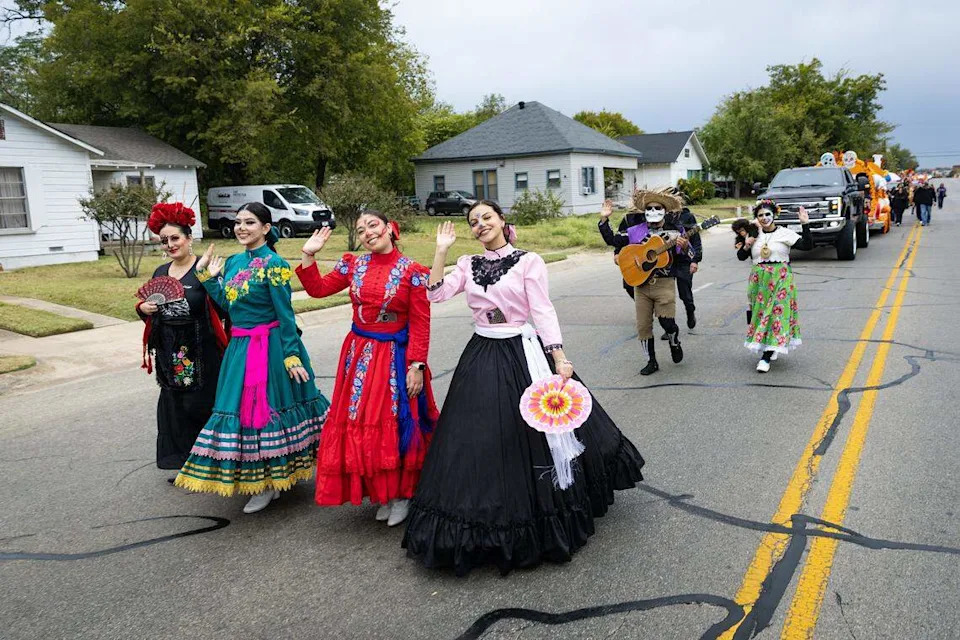 Parade participants from Ballet Folklorico Azteca de Fort Worth walk down Ellis Avenue for the Día De Los Muertos Parade in Northside Fort Worth on Saturday, Nov. 1, 2025.