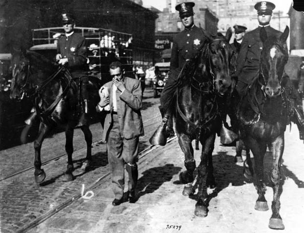 Mounted police officers round up "stray" Black residents and escort...