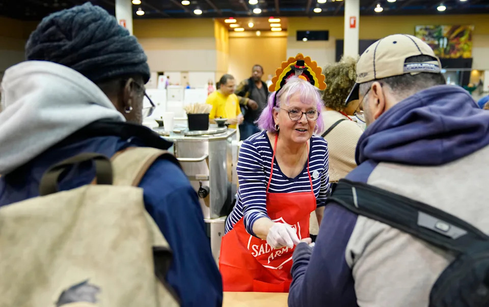 Lynn Arias serves coffee for those coming off the street during the Salvation Army Thanksgiving Day event at the Phoenix Convention Center in Phoenix on Nov. 27, 2025.