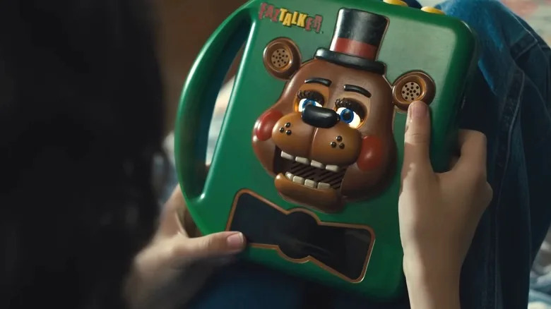 Abby holding a Freddy Fazbear talking box in 