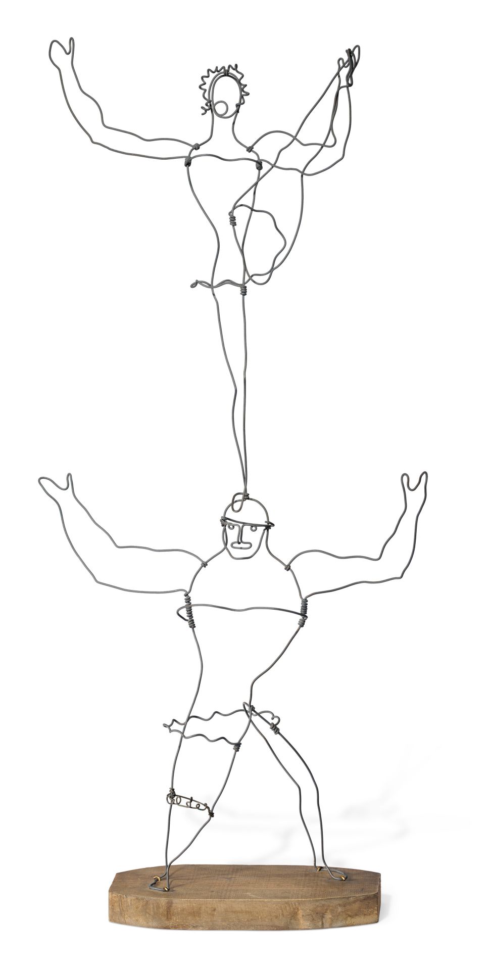 A wire sculpture of two acrobats: a muscular figure on the bottom balancing another performer above, both simplified into linear outlines mounted on a wooden base.
