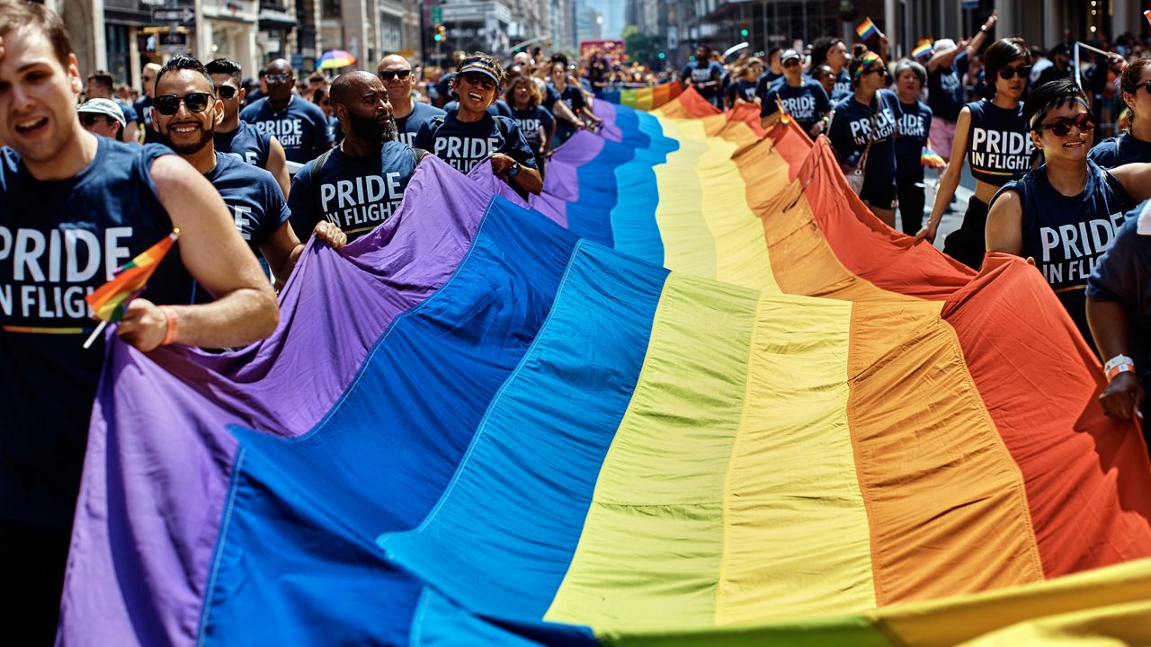 Revelers carry a LGBTQ flag along Fifth Avenue during the New York City Pride Parade on June 24, 2018. (AP Photo/Andres Kudacki)