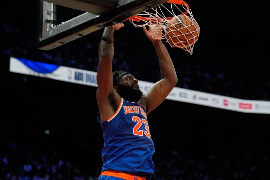 New York Knicks center Mitchell Robinson (23) dunks against the Philadelphia 76ers during the first half of an NBA preseason basketball game in Abu Dhabi, United Arab Emirates, Sunday, Oct. 4, 2025.