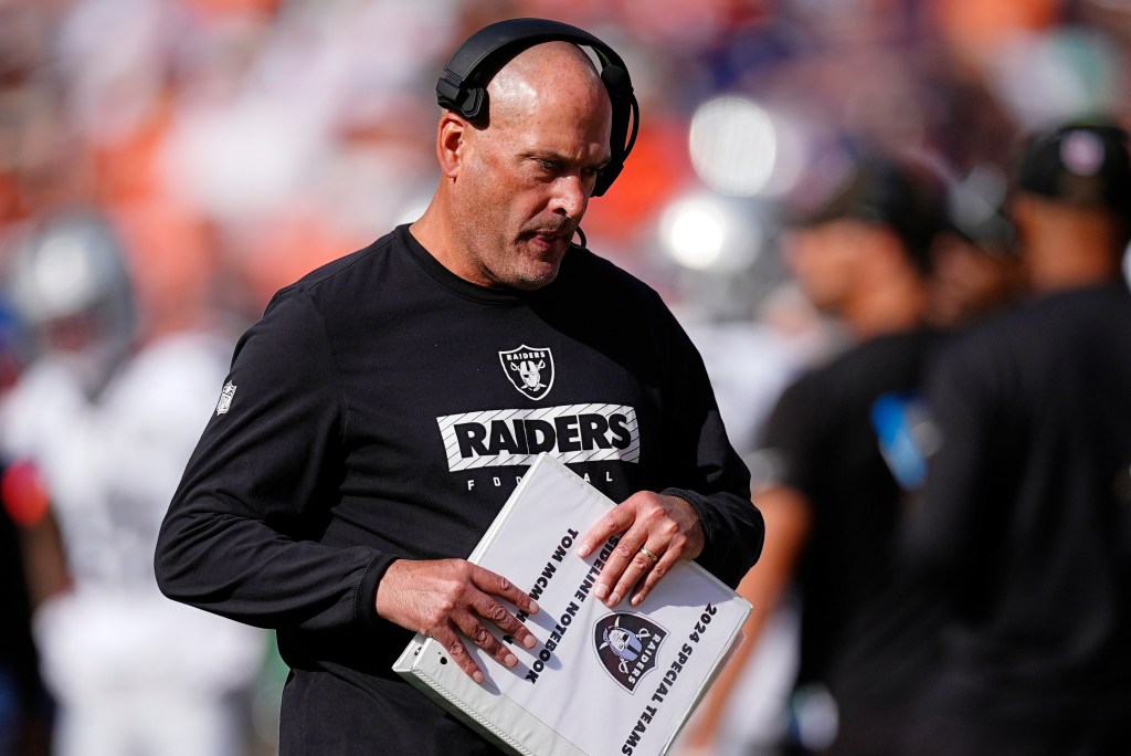 Tom McMahon in a black Raiders shirt, holding a white binder that reads "2024 Special Teams Sideline Notebook Tom McMahon."