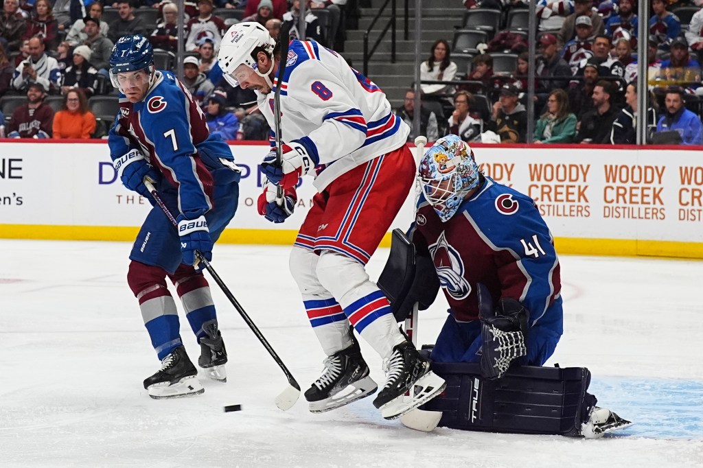 New York Rangers center J.T. Miller, center, tries to redirect the puck past Colorado Avalanche goaltender Scott Wedgewood, right, as defenseman Devon Toews covers in the second period of an NHL hockey game Thursday, Nov. 20, 2025, in Denver.