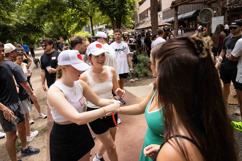 Bailey Turner (left) and Abbey Hagan greet guests and hand out wristbands during a Datey...