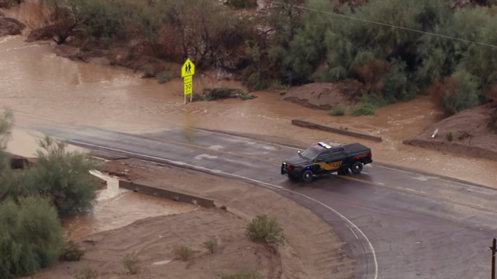A deputy blocks a road near Wickenburg due to flooding.