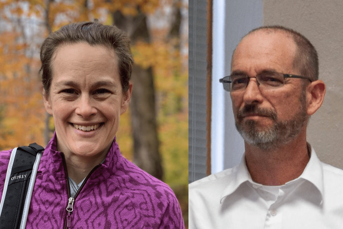 A woman in a purple patterned jacket smiles outdoors next to a man in glasses and a white shirt indoors.