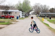 Mobile homes are seen past a child riding a bicycle, at Willow Lake Mobile Home, Thursday,...