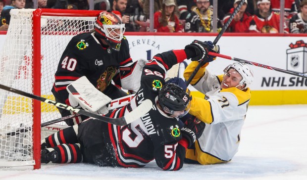 Blackhawks defenseman Artyom Levshunov (55) and Nashville Predators right wing Matthew Wood (71) collide in the goal and a interference penalty is called on Levshunov during the second period, Nov. 28, 2025, at the United Center. (Dominic Di Palermo/Chicago Tribune)