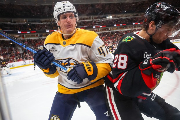 Nashville Predators right wing Michael McCarron (47) and Blackhawks left wing Andre Burakovsky (28) crash into the boards during the second period, Nov. 28, 2025, at the United Center. (Dominic Di Palermo/Chicago Tribune)