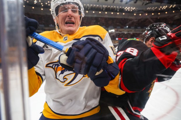 Nashville Predators right wing Michael McCarron (47) and Blackhawks left wing Andre Burakovsky (28) crash into the boards during the second period, Nov. 28, 2025, at the United Center. (Dominic Di Palermo/Chicago Tribune)