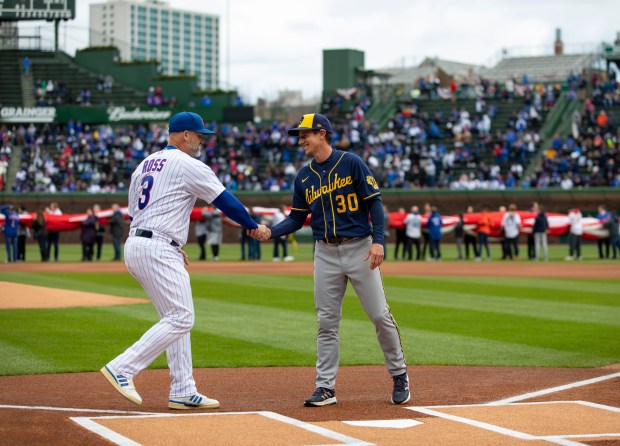 Chicago Cubs manager David Ross, left, meets Milwaukee Brewers manager Craig Counsell on April 7, 2022, on opening day at Wrigley Field. (Brian Cassella/Chicago Tribune)