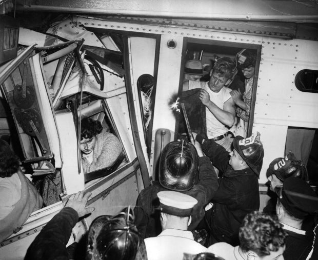 Firefighters, some with acetylene torches, hurry to reach trapped victims after two trains collided during rush hour on Nov. 5, 1956, in Chicago. A northbound CTA elevated train crashed into a North Shore train at at the Wilson Avenue station, just west of Broadway. (Chicago Tribune historical photo)
